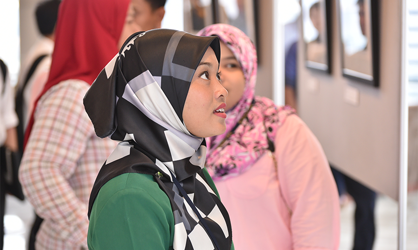 Woman looking at one of the pictures making up part of the exhibition