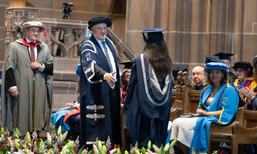 LJMU Vice-Chancellor Mark Power stood on a stage adorned with flowers handing out graduation awards